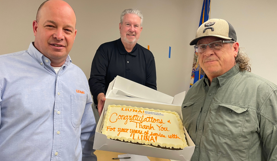 Joel Smith, Terry Healy and Sheldon Steele holding his retirement cake.