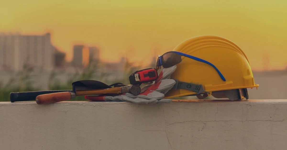 Hard hat and tools in front of a sunset.